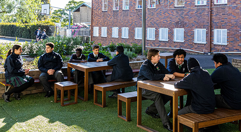 Positive Behaviours and happy students sitting outdoors at Delany Catholic College Granville
