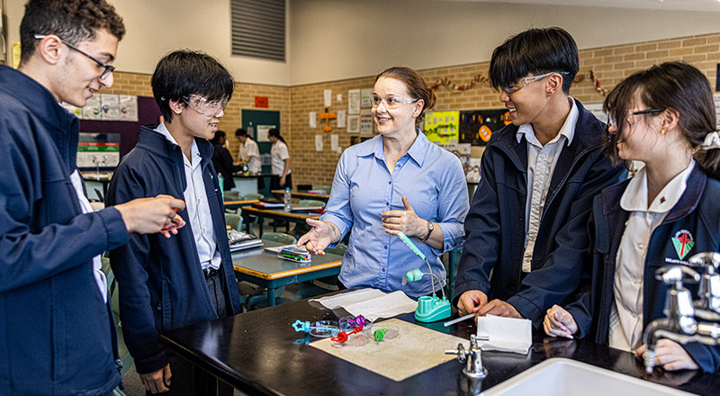 Science teacher with students at Delany Catholic College Granville