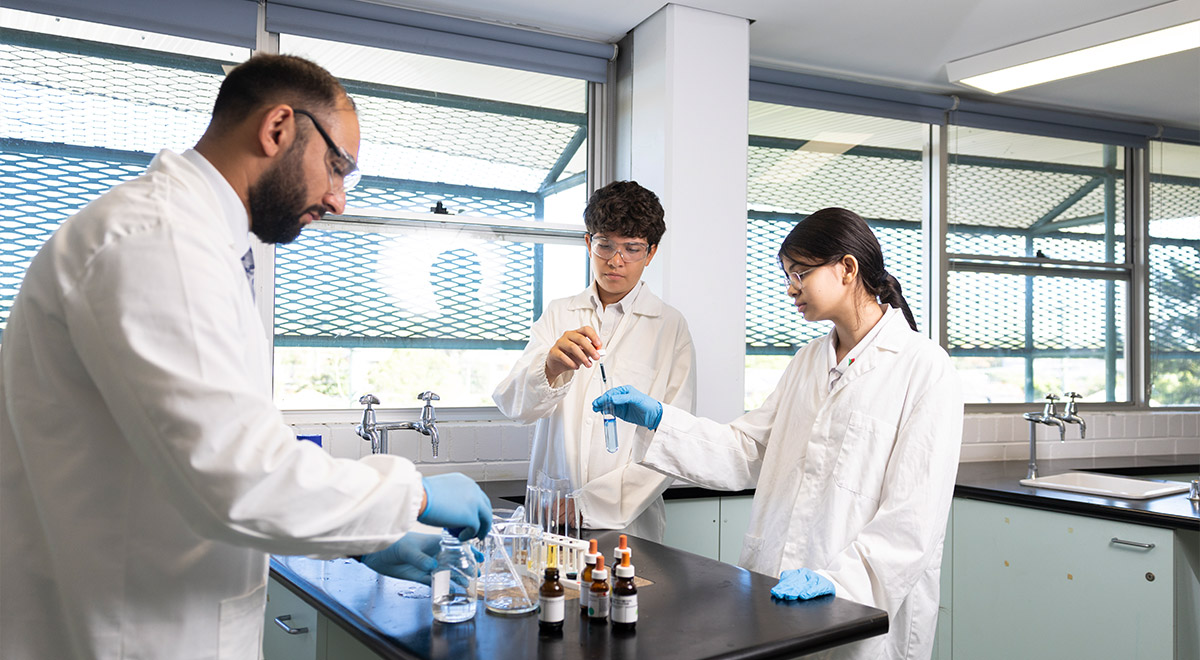 Science teacher at Delany Granville assisting students in lab