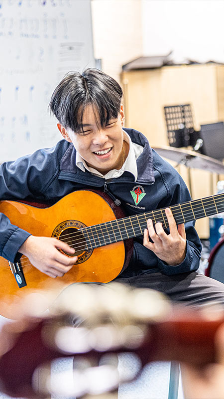 Delany College Granville students in music lessons. They are playing the acoustic guitar.