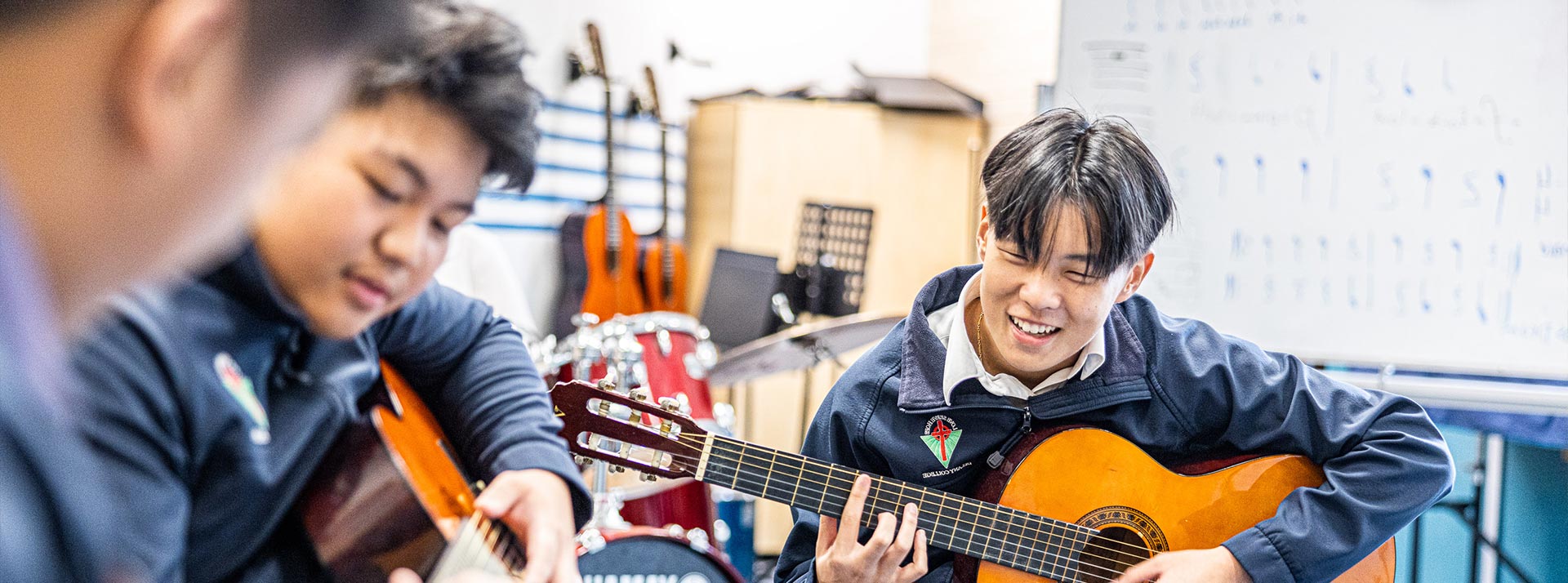 Delany College Granville students in music lessons. They are playing the acoustic guitar.