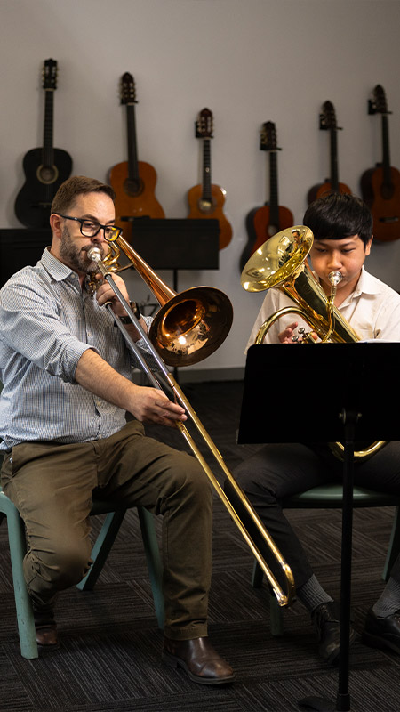 Music lessons at Delany Granville. The music teacher is giving a lesson on brass section
