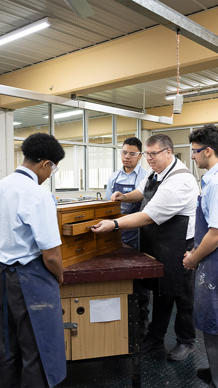 Woodwork teacher assisting Delany College Granville students with their woodwork project