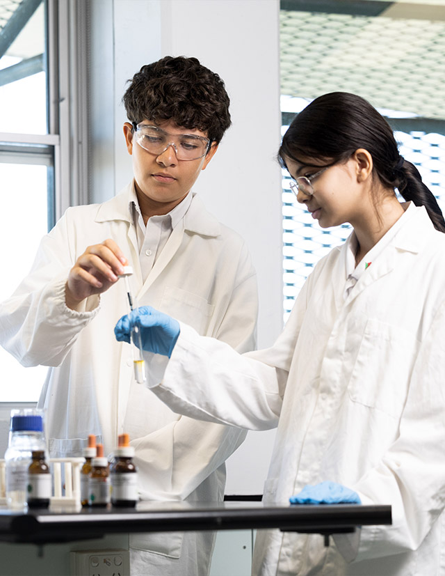 Delany Granville students in science class. Students in lab, holding a test tube.