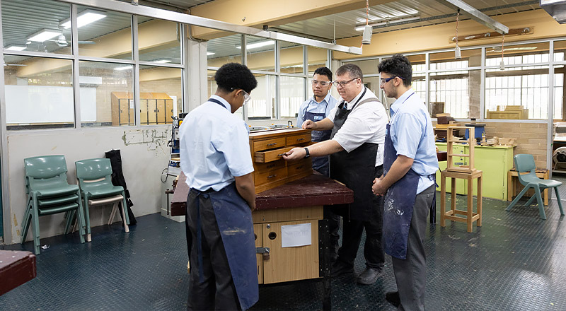 Woodwork teacher assisting Delany College Granville students with their woodwork project