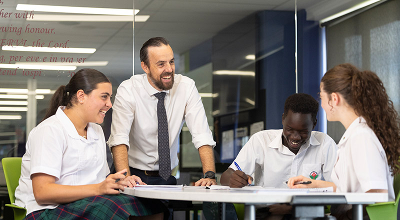 Delany College teacher assisting students in class