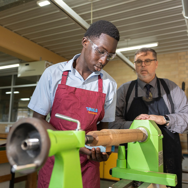 Delany College Granville teacher assisting students in woodwork construction 