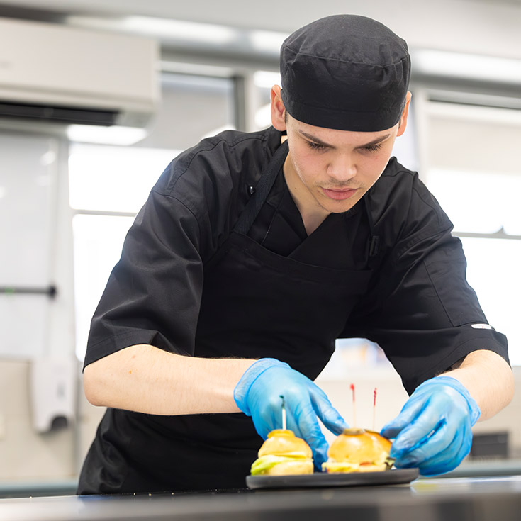 Food Tech Hospitality student assembling a burger