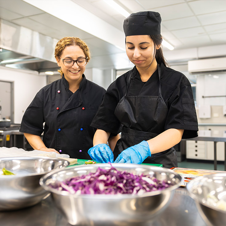 Food Tech teacher assisting Delany College Granville students with preparing hamburgers